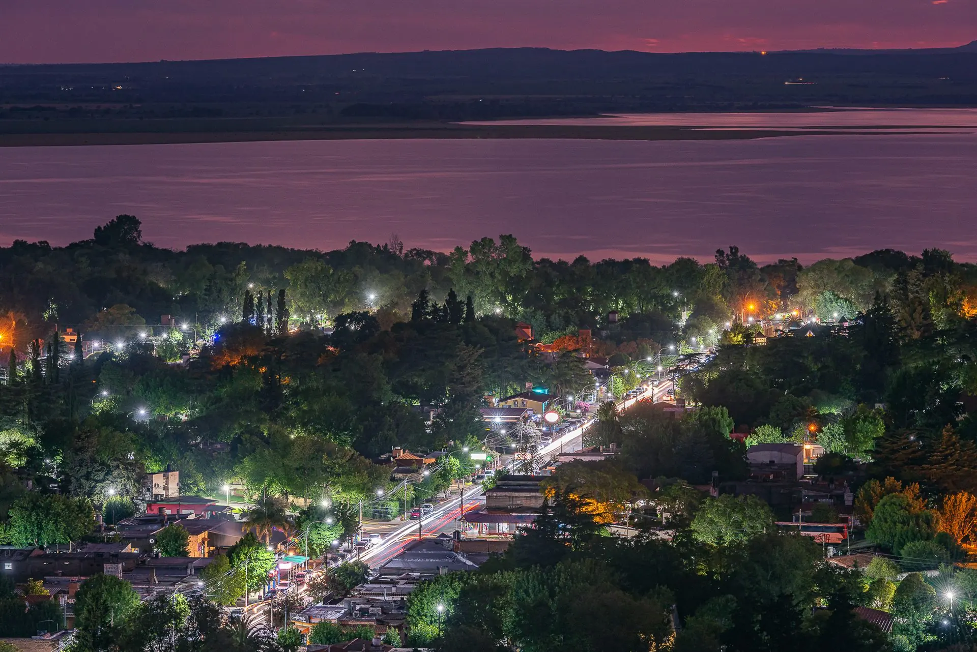 Villa Rumipal iluminada junto al lago al caer la noche